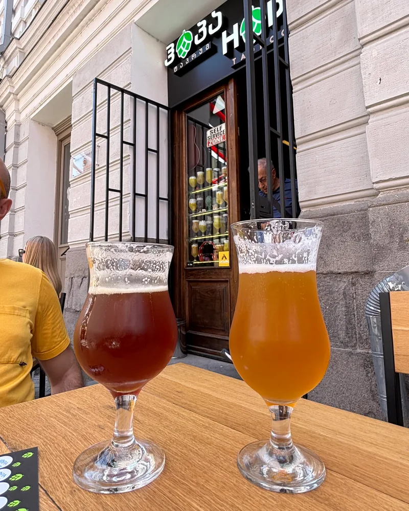 Two glasses of craft beer on an outdoor table at HOPA Taproom