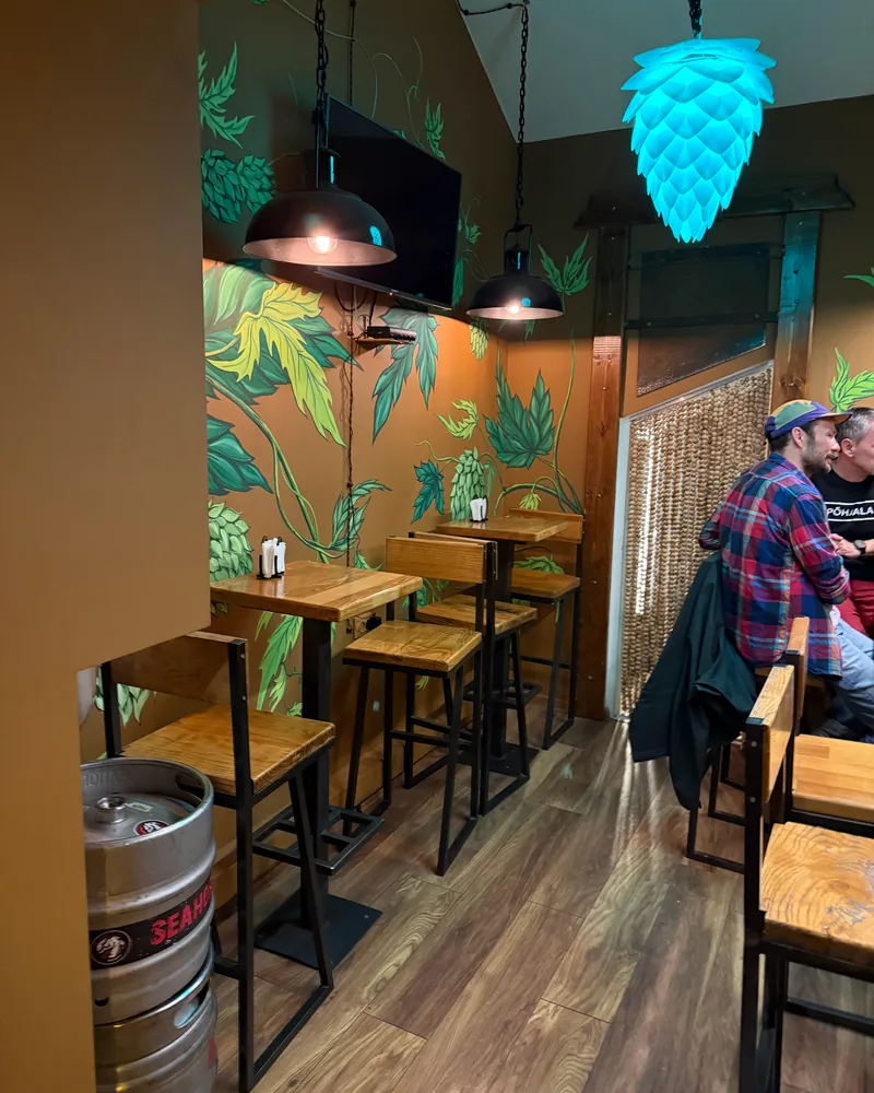 Small seating nook with painted mural and hop-shaped light at HOPA Taproom