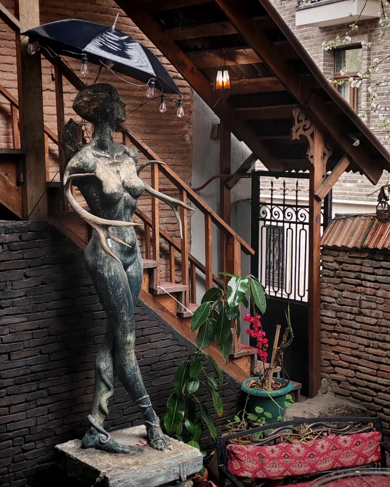 Courtyard statue and wooden staircase at Impulse