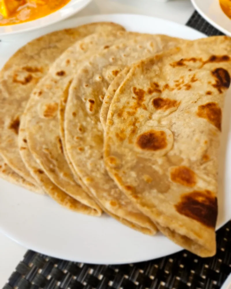 Roti flatbreads on a white plate at Indian Express