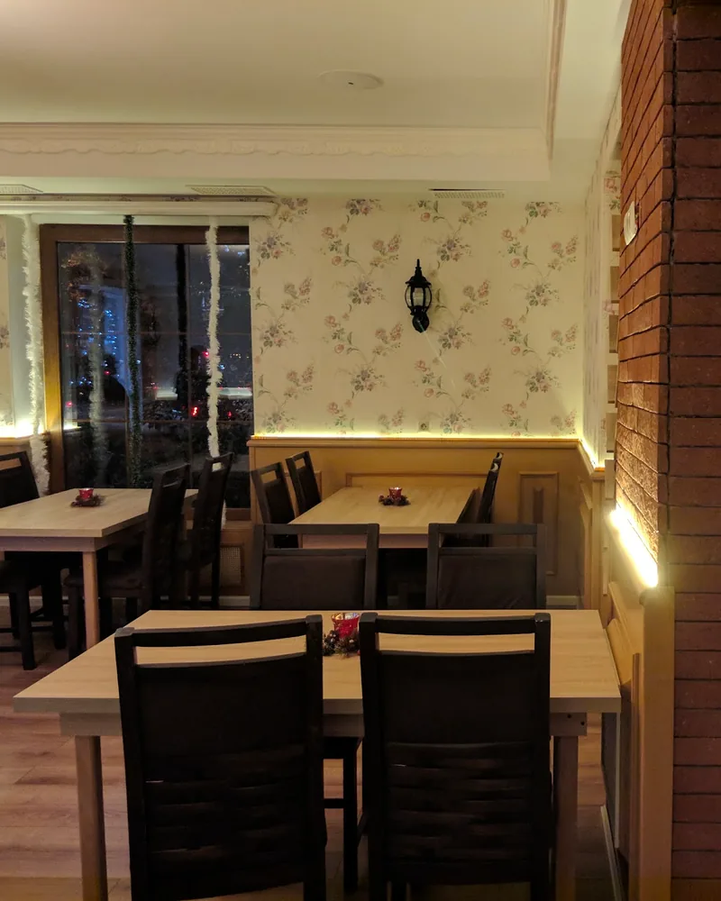 Dining room with brick pillar and floral wallpaper at Indian Express