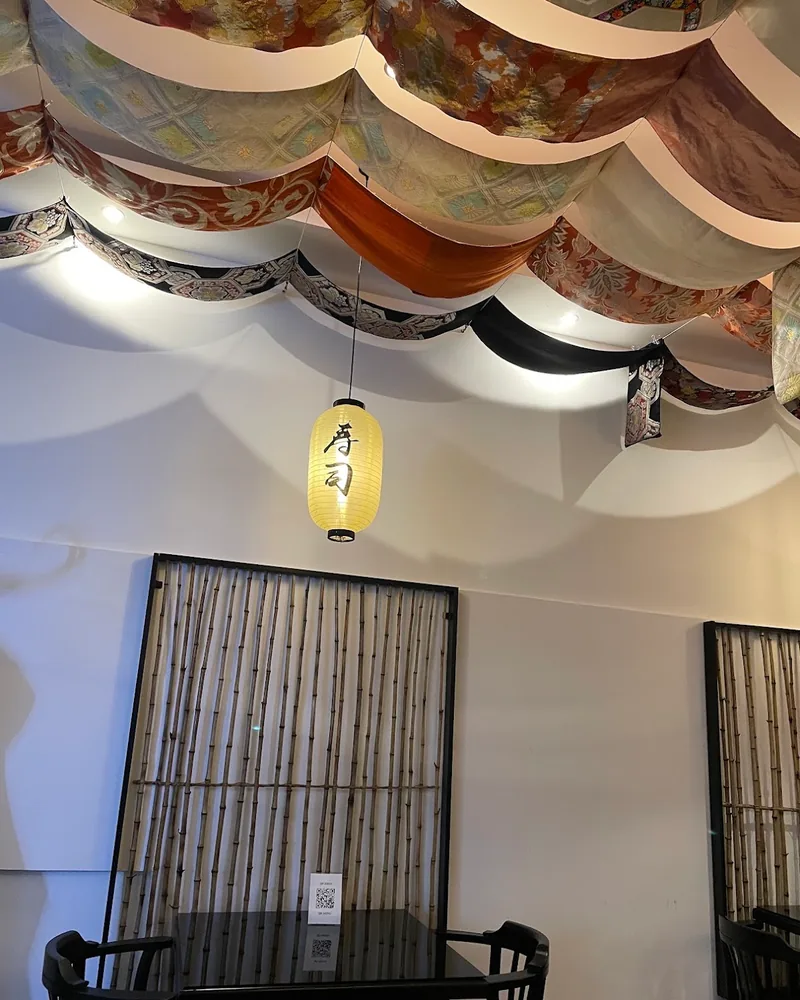Dining area with draped fabric ceiling and a paper lantern at iSushi