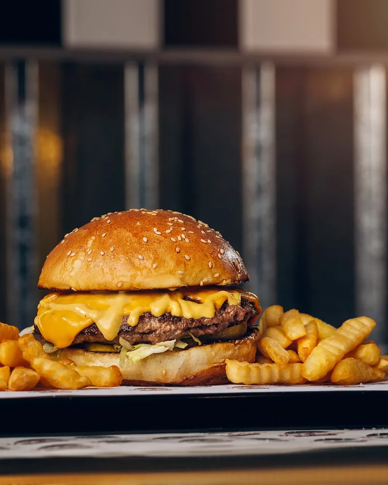 Cheeseburger with crinkle-cut French fries at Just Burgers