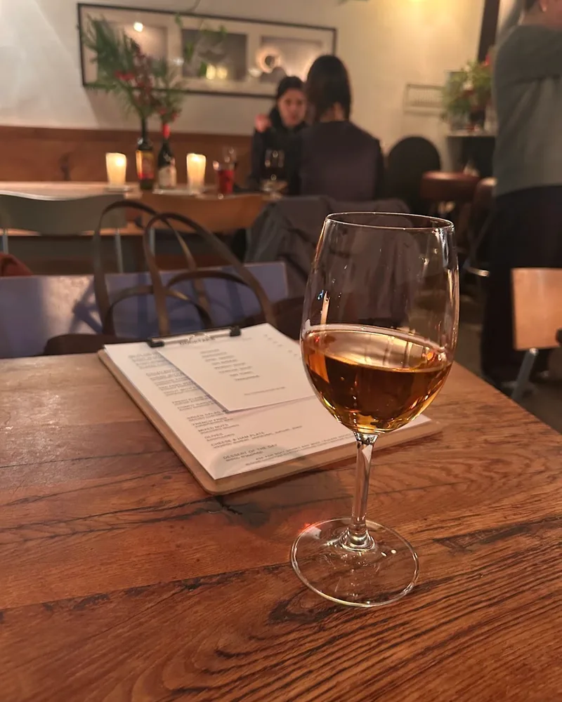 Amber wine in a stemmed wine glass at Kancellaria Natural Wine Bar