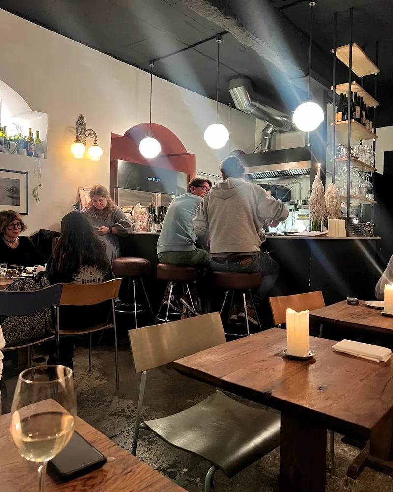 Wine bar interior with counter and candlelit tables at Kancellaria Natural Wine Bar