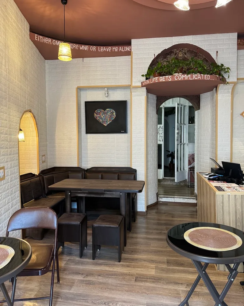 Dining area with booths and small round tables at KaPaoBox