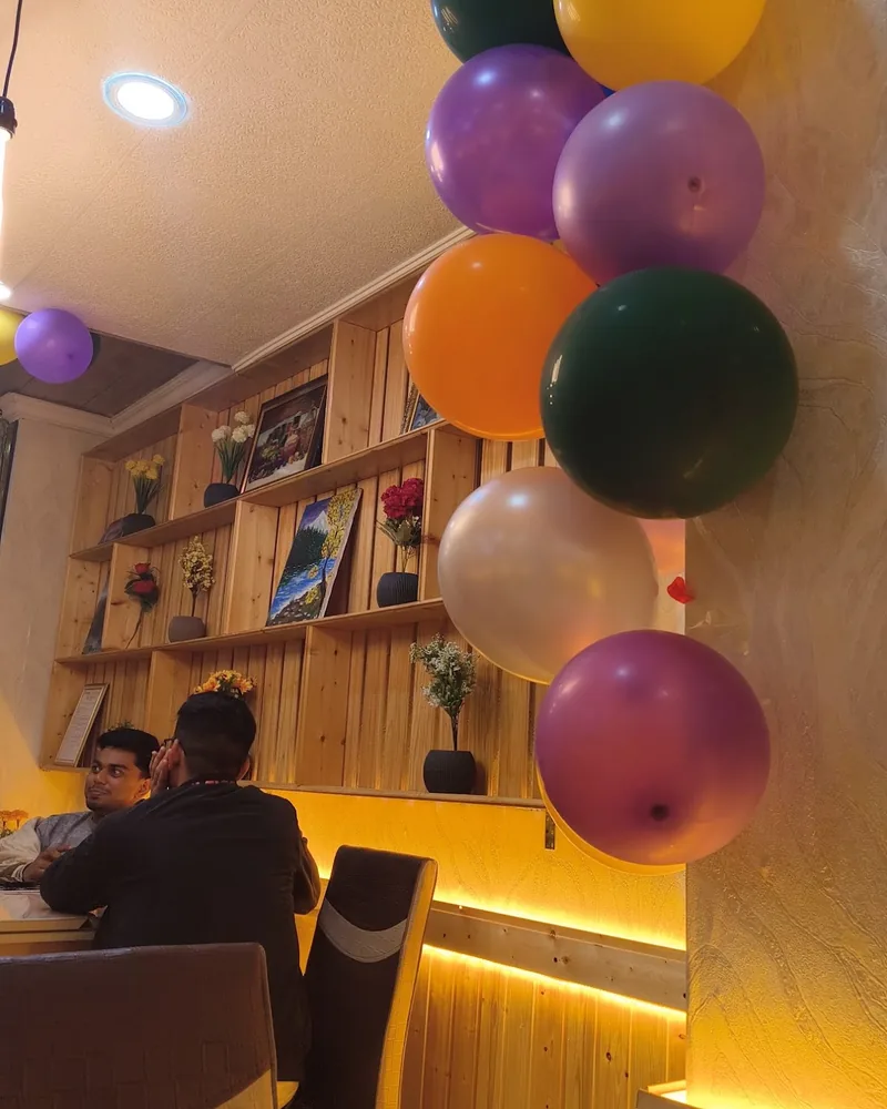 Dining area with wood panelled shelves and balloons at Karak House