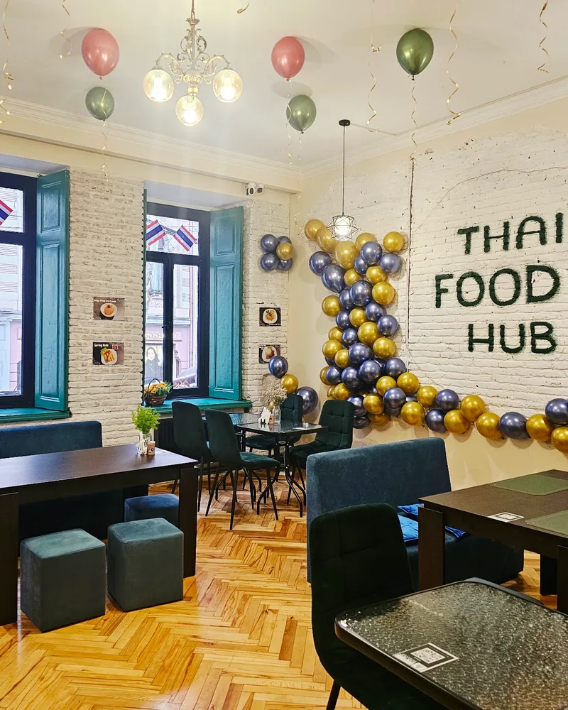 Dining room decorated with balloons and a branded brick wall at Kasorn Thai Cuisine