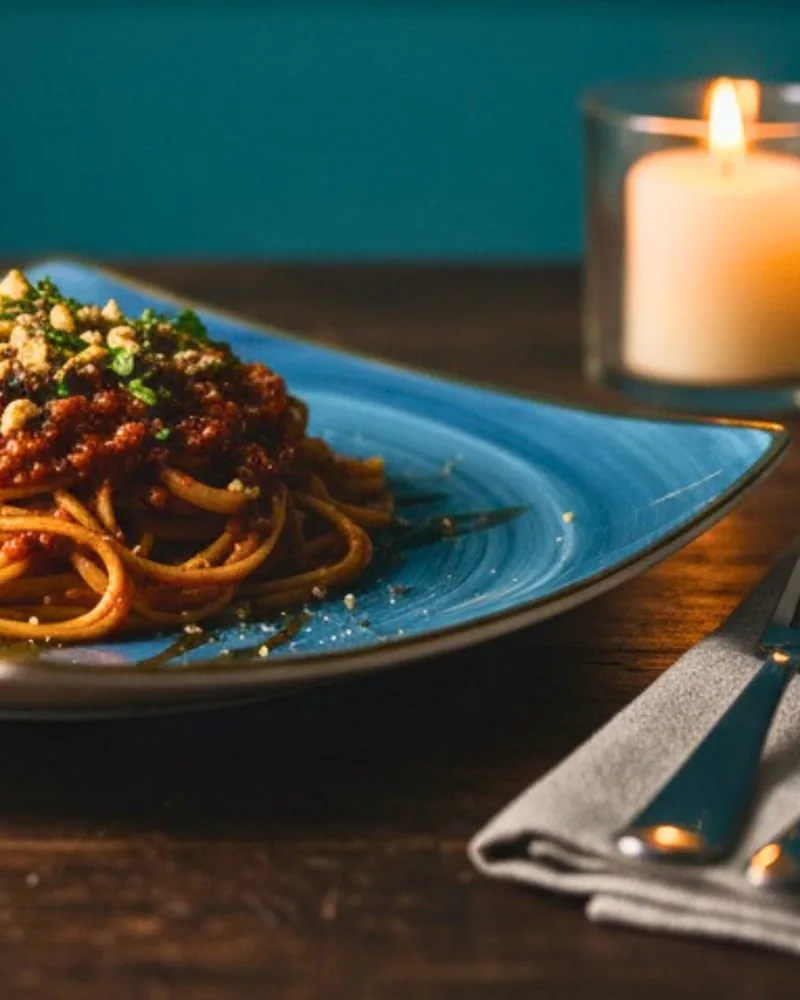 Spaghetti bolognese on a blue ceramic plate at Kava Lebanese Restaurant