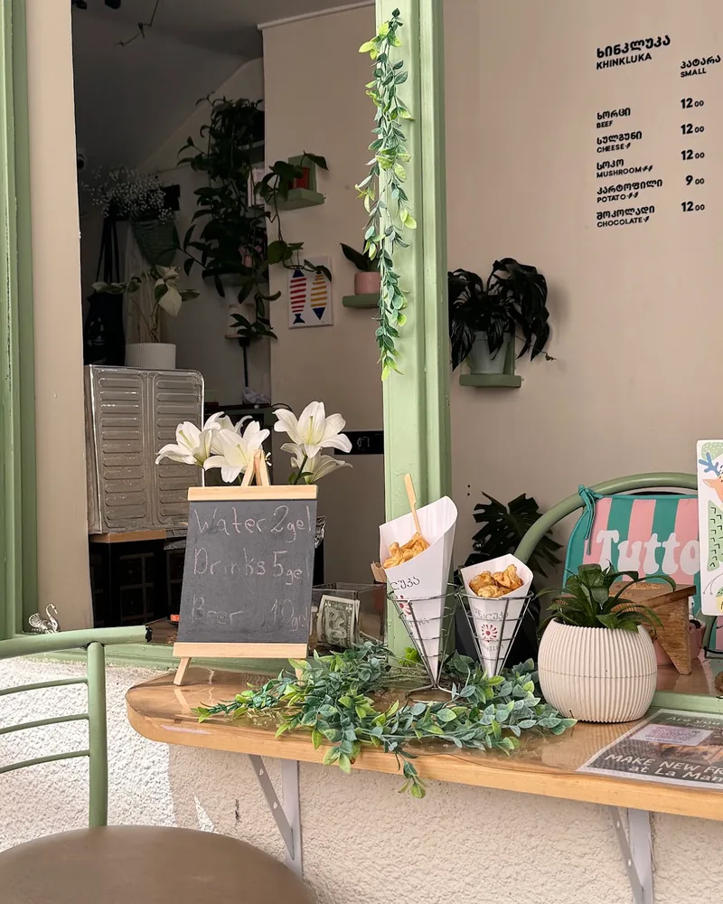 Counter window with mini khinkali cones and chalkboard menu at Khinkluka