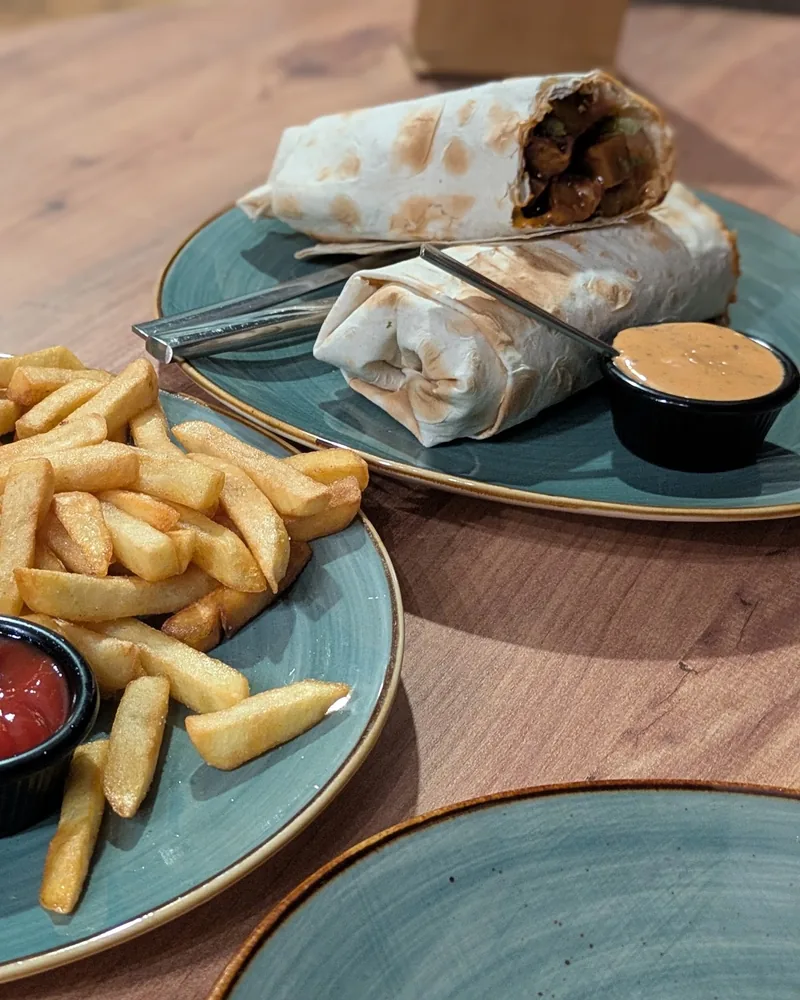 2 lavash wraps with dipping sauce and a plate of fries at Kiwi Vegan Cafe