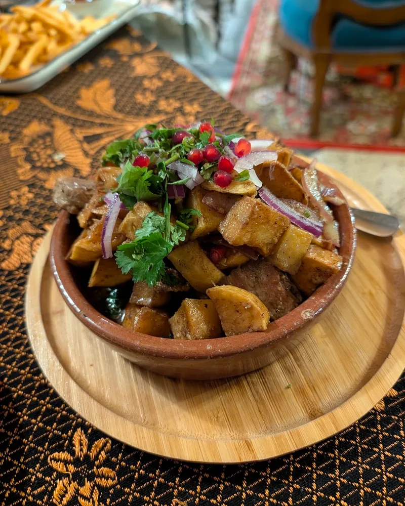 Ojakhuri topped with herbs, onions, and pomegranate seeds at Kneina