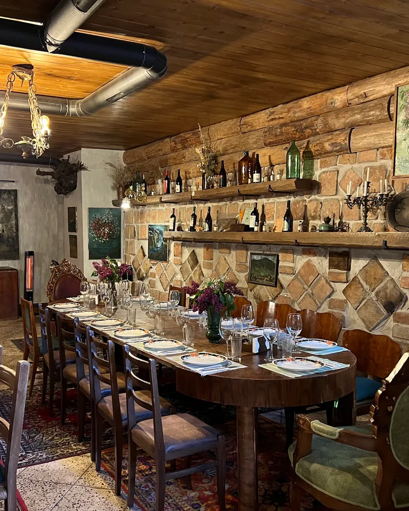 Rustic dining room set for a banquet with log walls and stone details at Kneina