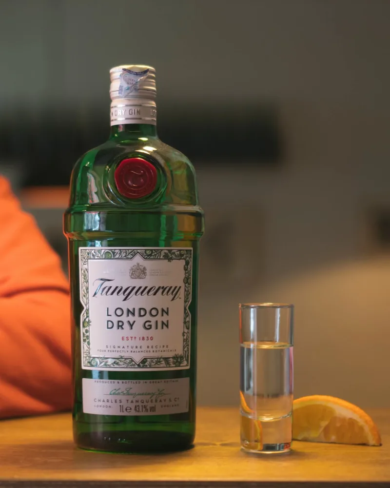 Tanqueray gin bottle with shot glass and orange slice at Krebuli Natural Wine Bar