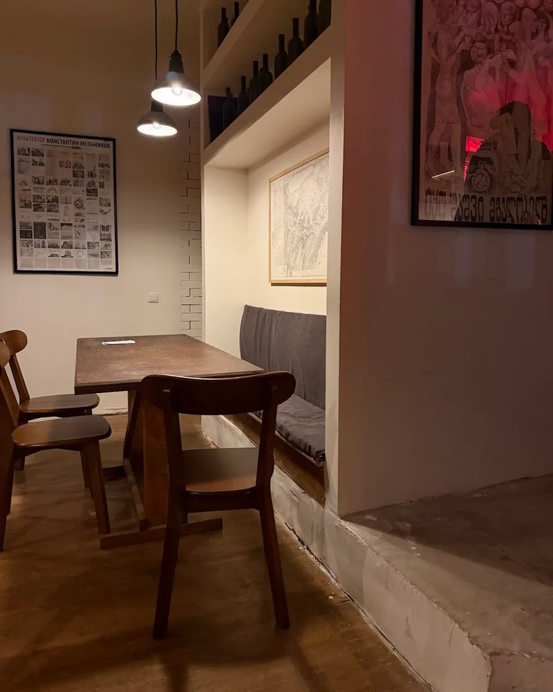 Seating nook with table, bench and chairs at Krebuli Natural Wine Bar