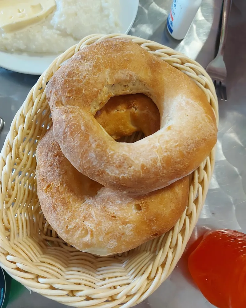 Round flatbreads in a woven basket at Lazuri Bakery