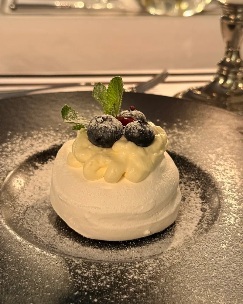 Pavlova topped with cream and blueberries at Le Marais de Mome