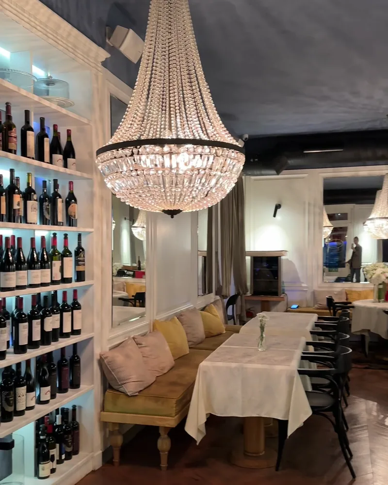 Dining room with crystal chandelier and wine shelves at Le Marais de Mome