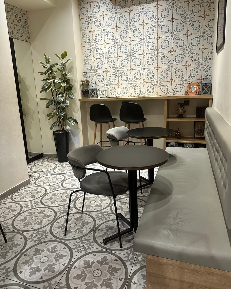 Cafe seating area with tiled floor and wallpaper at Liel Chimney Cake & Coffee