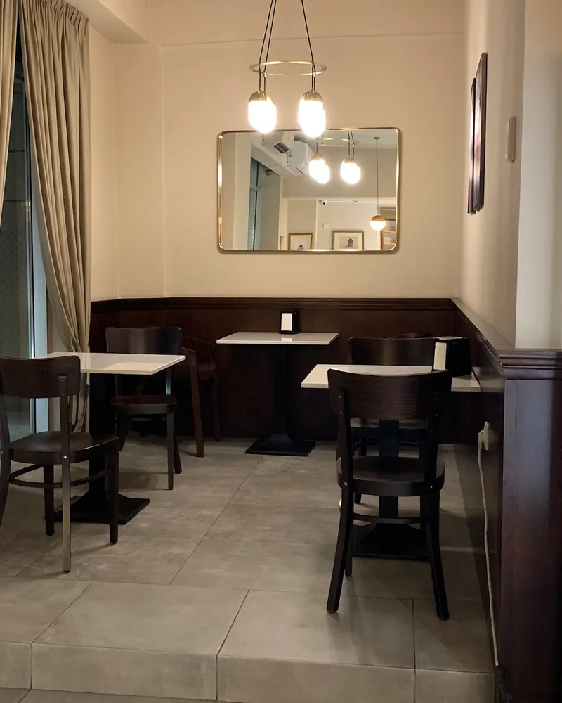 Cafe seating area with tables and wooden chairs at Lika