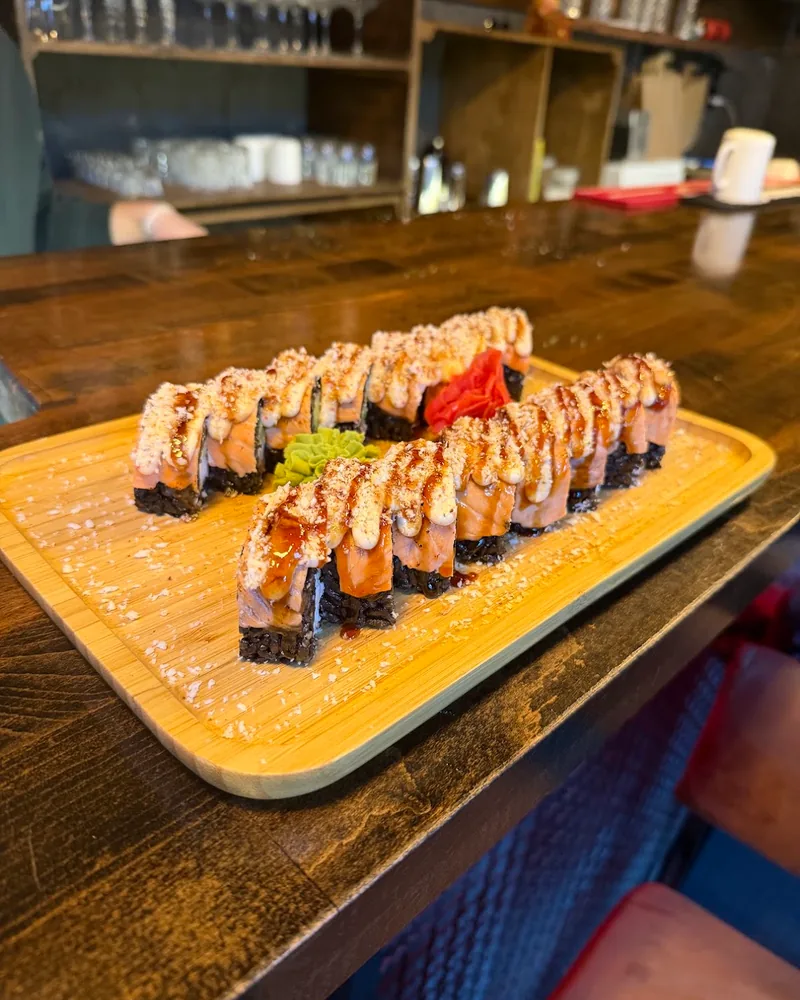 Black rice sushi rolls on a wooden tray at Lion's Sushi Bar
