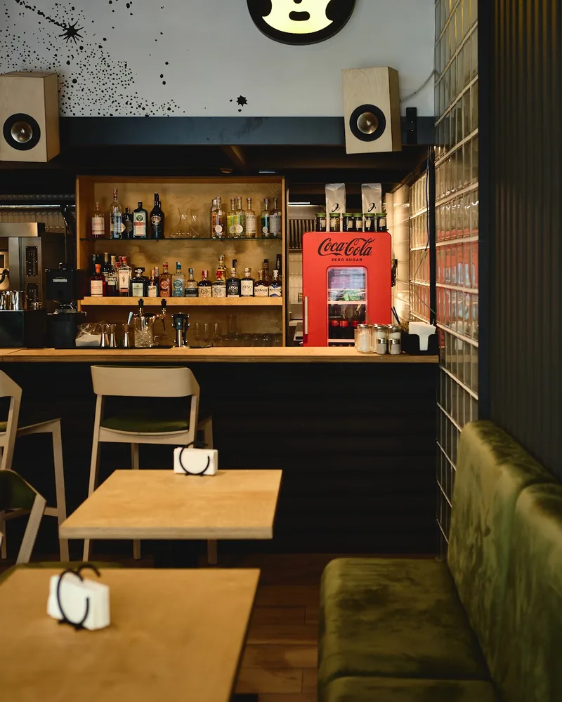 Seating area and bar counter with circular wall art at Luna Pizza Bar