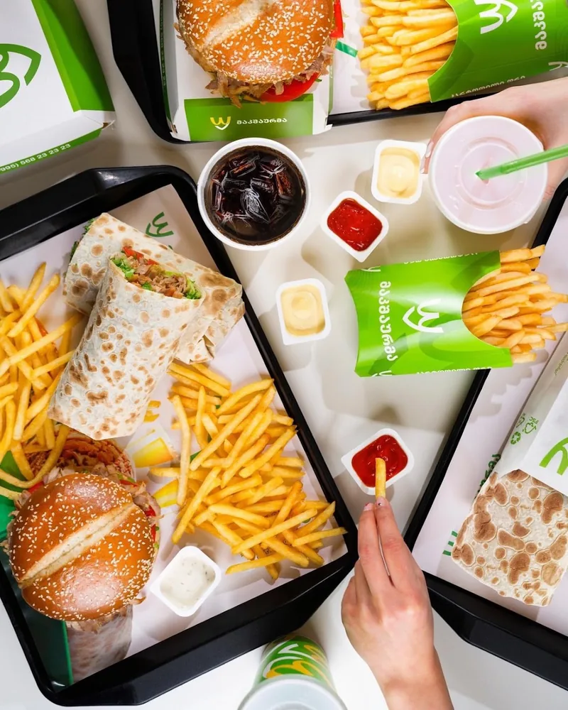 Fast food spread with burgers, shawarma wraps, and fries at MacShaurma