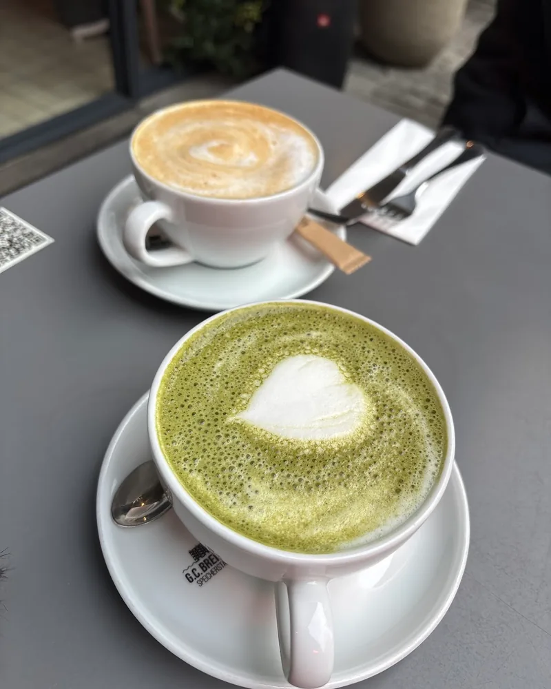 Matcha latte and cappuccino in white cups at Madame Choux