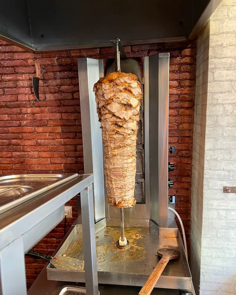 Shawarma spit with layered rotating meat at Magical Shawarma