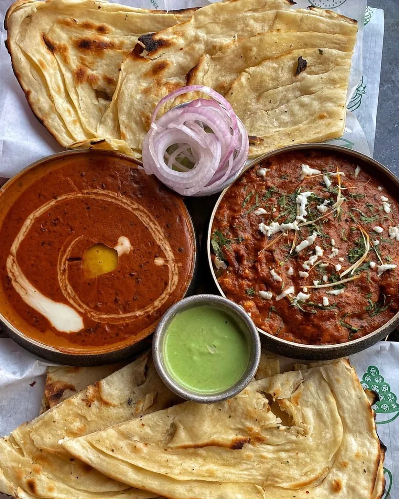 Indian curry platter with naan and chutneys at Masha Allah