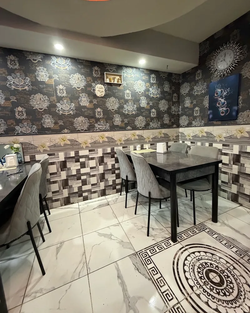 Dining tables with wallpaper and tiled wall at Mashallah Indian Restaurant