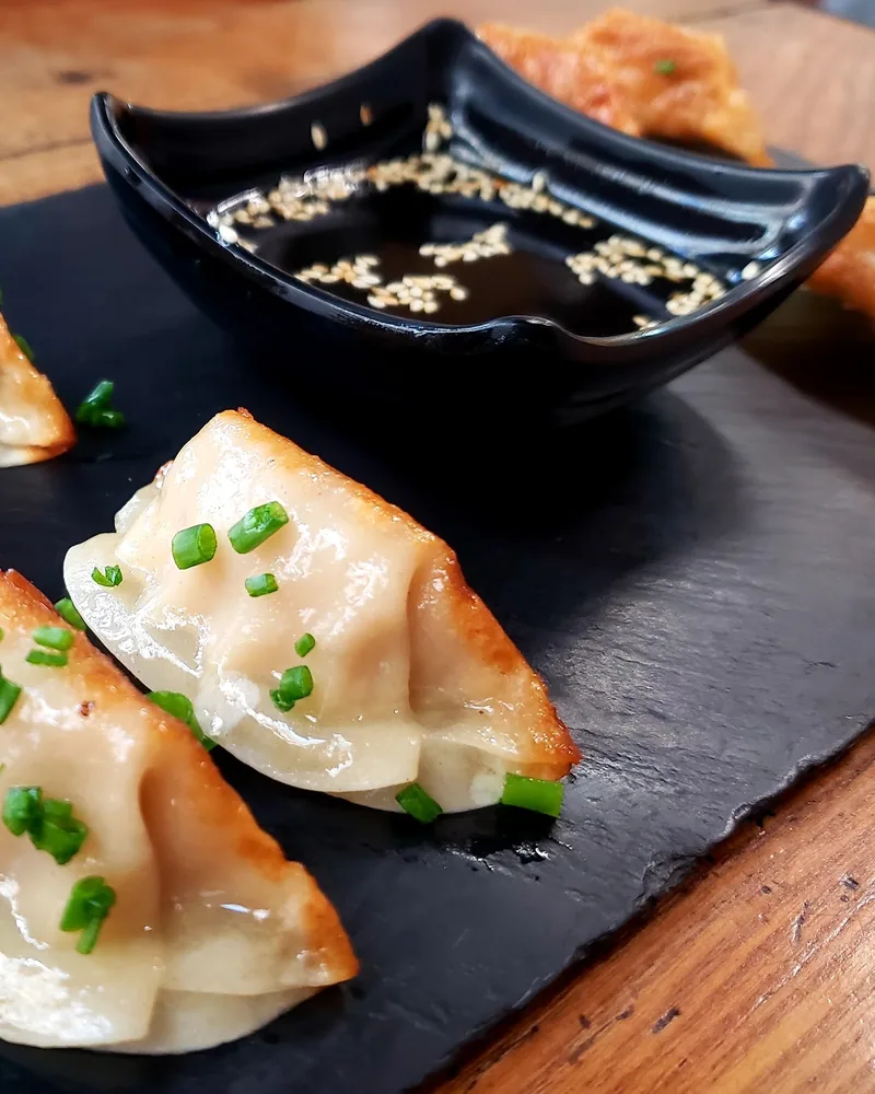 Pan-fried gyoza dumplings with dipping sauce at Mochi