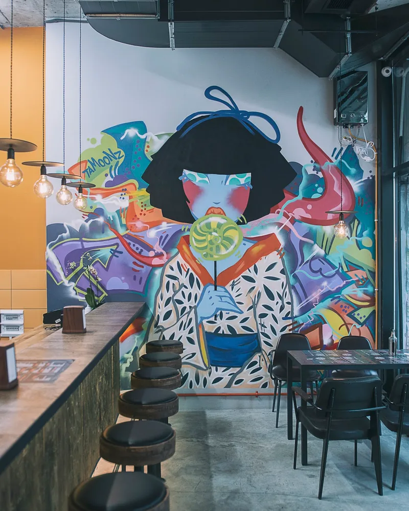 Counter and dining space with a mural at Mochi