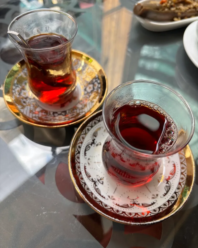 Two glasses of turkish tea on saucers at Mr Kabab