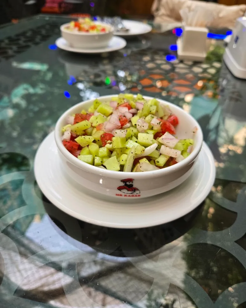 Chopped salad in a small branded bowl at Mr Kabab
