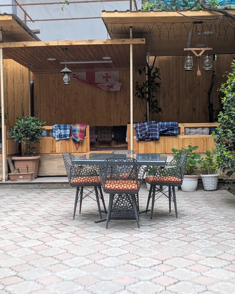 Outdoor courtyard seating with wooden booths and table at Mr Kabab