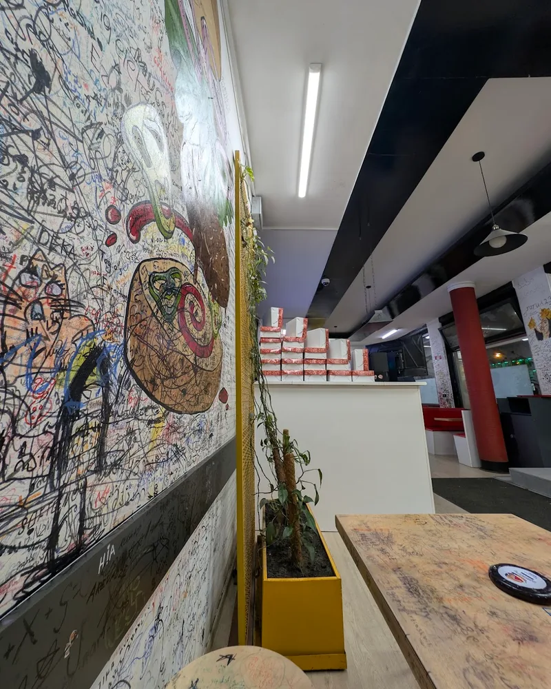 Graffiti-covered wall and seating area at Mugsy's Burger