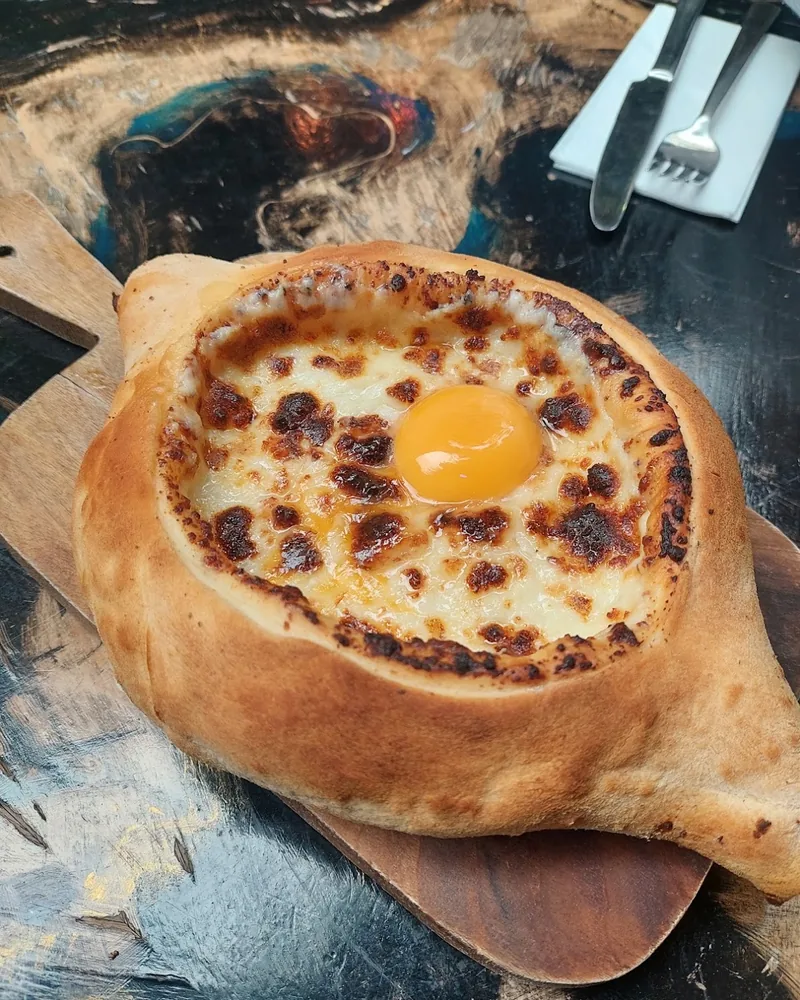 Adjarian khachapuri on a wooden board at Muse