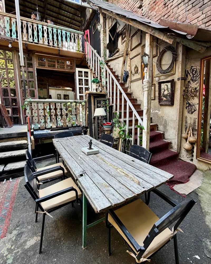 Rustic courtyard dining area with wooden table and vintage decor at Muse