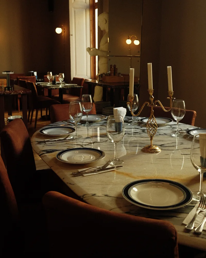 Marble dining table set with candelabra and wine glasses at Mussels Place