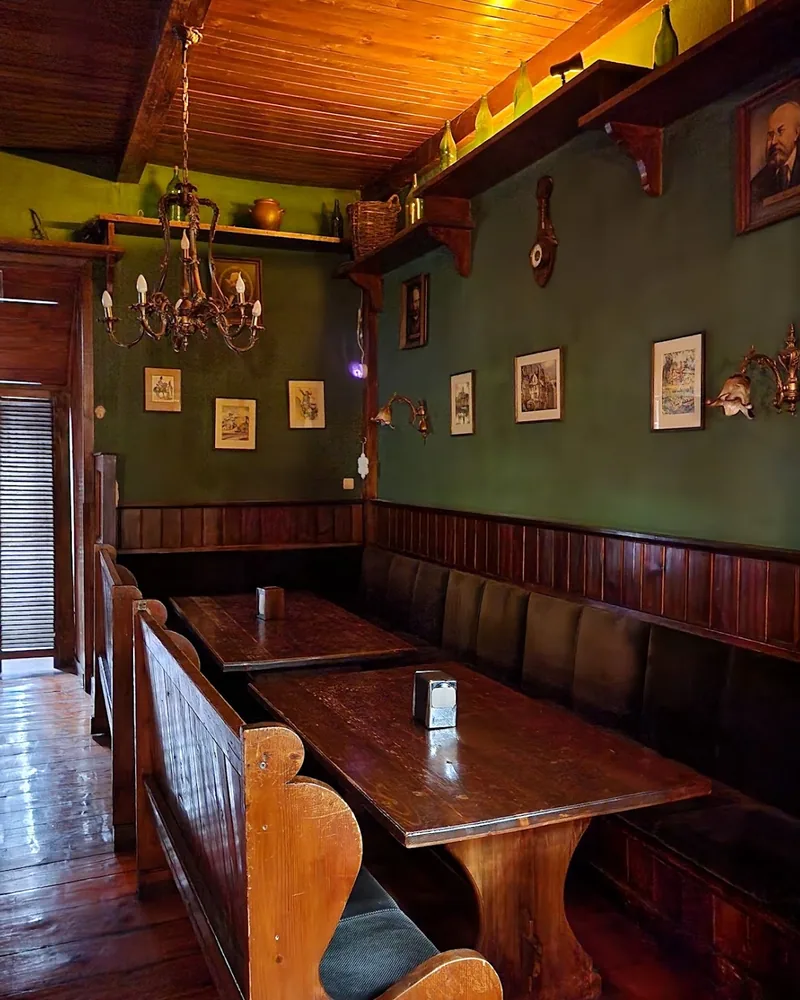 Wooden booths and green walls in a pub dining area at Nali Stage Pub