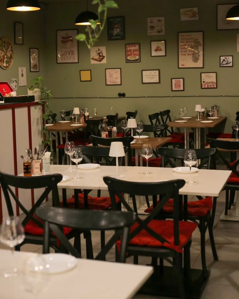 Dining room with wooden tables and framed art at Napoli