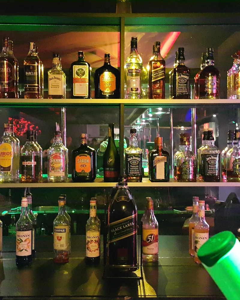 Back bar shelves with liquor bottles at Night Office