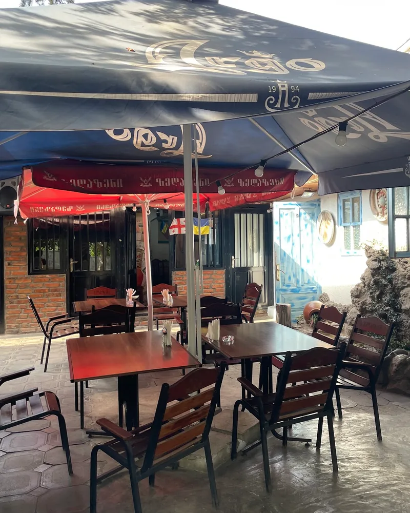Courtyard patio dining area under large umbrellas at Nikala's Yard