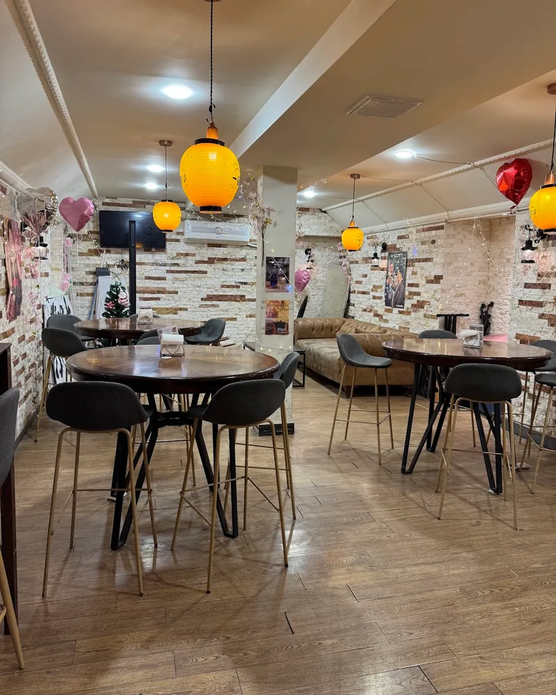 Dining area with high tables and paper lanterns at Nozomi Bar