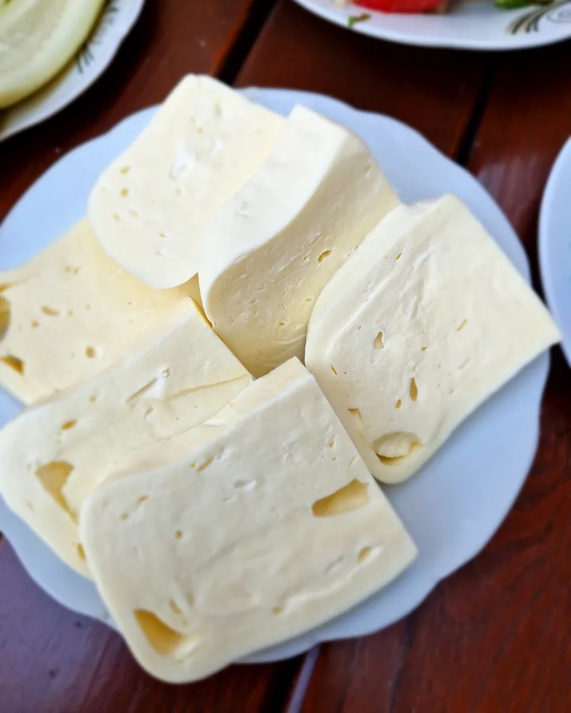Sliced sulguni cheese on a white plate at Ochamchire