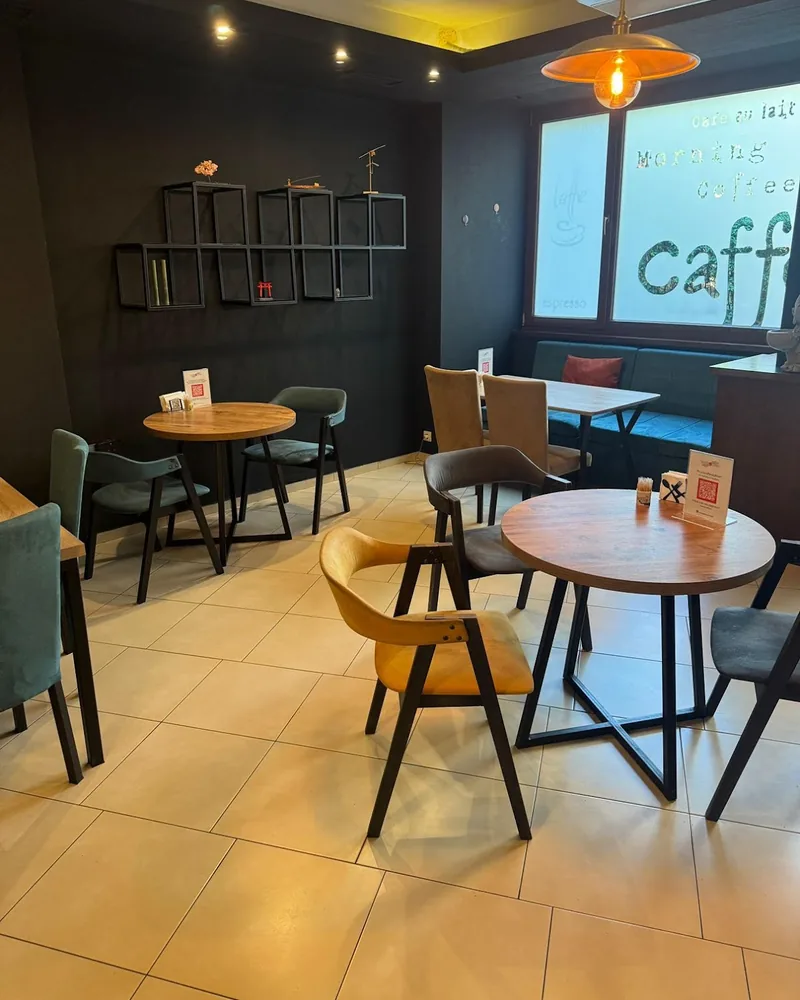 Cafe dining area with wooden tables and chairs at Oishi Sushi