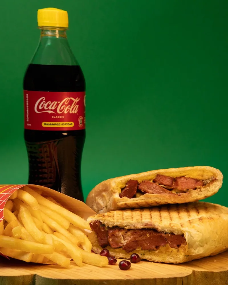 Pressed meat sandwich with french fries and bottled coca-cola at OK Shawarma