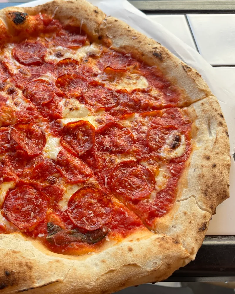 Pepperoni pizza on parchment paper at Olio