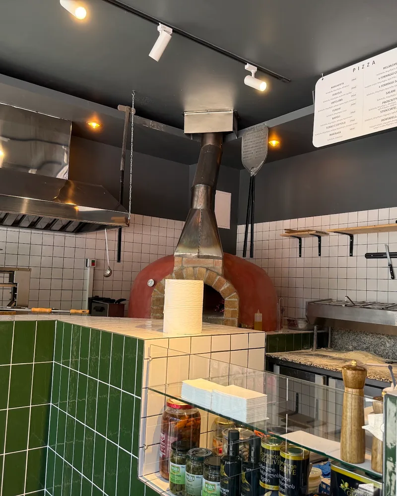 Open kitchen with pizza oven and tiled counter at Olio